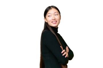 Young Asian woman over isolated chroma key background looking to the side and smiling