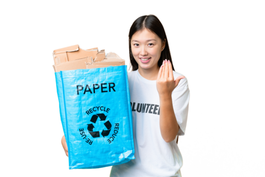 Young Asian woman holding a recycling bag full of paper to recycle over isolated chroma key background inviting to come with hand. Happy that you came