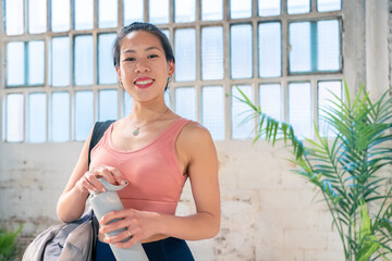 Sporty asian woman with a bottle of water in the gym. Healthy lifestyle concept. High quality photo