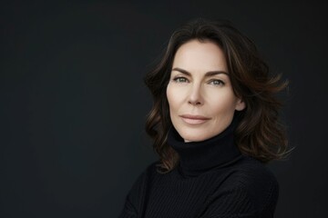Fototapeta premium Confident middle aged woman in black turtleneck sweater poses.