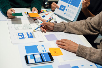 UX developer and ui designer brainstorming about mobile app interface wireframe design with...