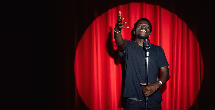 African, american man comic in costume performing standup monologue on stage with red curtains. Concept comedian show banner