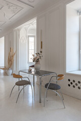 bright interior design of spacious living room with white walls and decorative unique historical moldings on ceiling stylish modern furniture in warm colors without people daylight through the windows