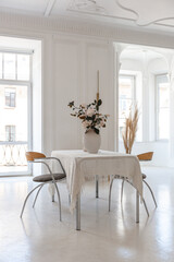 bright interior design of spacious living room with white walls and decorative unique historical moldings on ceiling stylish modern furniture in warm colors without people daylight through the windows