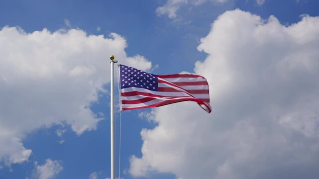 Waving USA flag flying on a flagpole, slow motion, medium shot, low angle