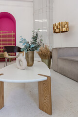 bright interior design of spacious living room with white walls and decorative unique historical moldings on ceiling stylish modern furniture in warm colors without people daylight through the windows