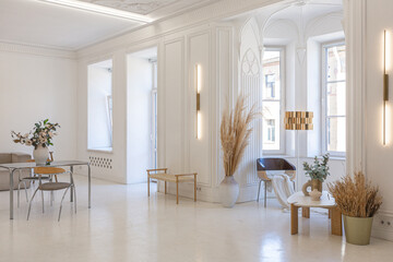 bright interior design of spacious living room with white walls and decorative unique historical moldings on ceiling stylish modern furniture in warm colors without people daylight through the windows