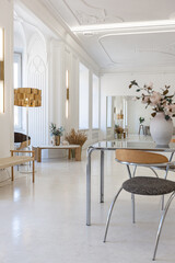 bright interior design of spacious living room with white walls and decorative unique historical moldings on ceiling stylish modern furniture in warm colors without people daylight through the windows