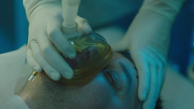 Surgeon putting a breathing mask onto patient's face