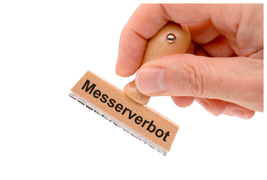 Ein Holzstempel ist beschriftet mit dem Aufdruck: Messerverbot