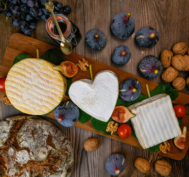 Selection of French cheeses from Normandy, AOP, Livarot, Neufchatel, Pont l'eveque, Rye bread, figs, walnuts, grapes, elderberry gelee. High quality photo