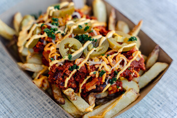 Pommesgericht mit Bolognese und einer K&auml;sesauce, Closeup