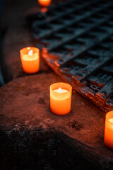 Brennende Kerzen und Teelichter auf einer Steinmauer