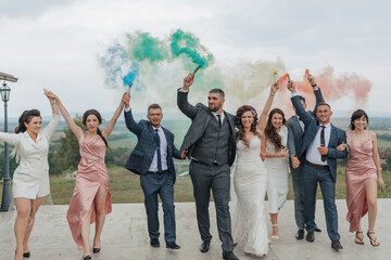 A group of people are posing for a photo, with some of them holding smoke bombs. Scene is celebratory and fun, as the group is likely celebrating a special occasion like a wedding or a birthday