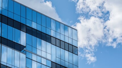 Modern Glass Office Building Against a Blue Sky with White Clouds