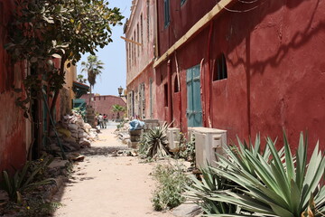 Vue d'une ruelle de l'île Gorée au Sénégal, bordée de maisons aux façades colorées. Longue...