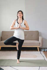Obraz premium Asian young woman doing yoga stretching exercise on mat yoga, fitness exercises. Healthy lifestyle Calmness and relax at home.