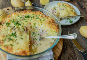 Classic german potato casserole with ham, eggs, heavy cream and cheese crust