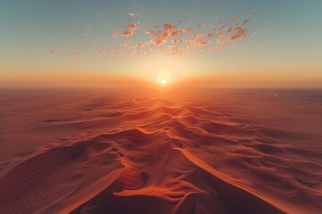 Golden sand dunes stretch across the horizon as the sun sets, painting the sky with vibrant hues of orange and pink