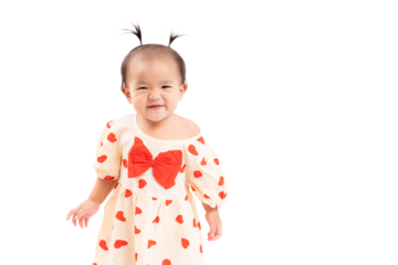 Adorable toddler with pigtails standing and smiling against a white background. The image captures the innocence and joy of childhood. Toddler girl looks at camera with smile face copy space