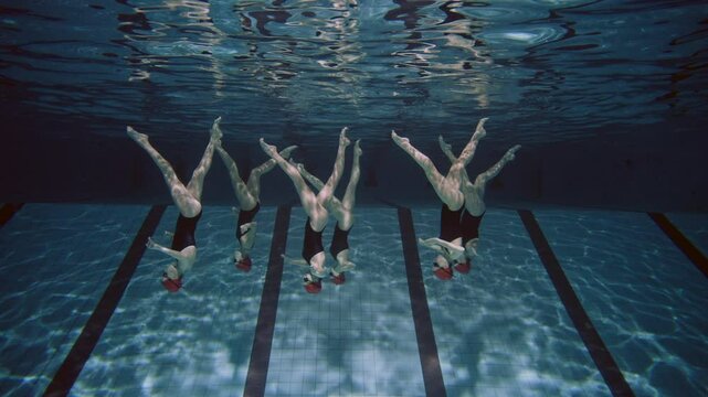 Women practicing synchronized swimming in the pool