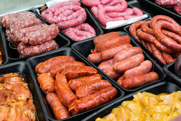 raw meat for sale in a butcher shop. There is spicy chorizo, sweet chorizo, sausages, red meat and spicy chicken