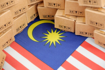Malaysian export and tariffs concept. Production from Malaysia. Flag of Malaysia and many carton...