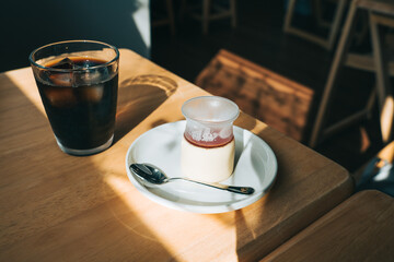 カフェのテーブルに置かれたアイスコーヒーとプリン