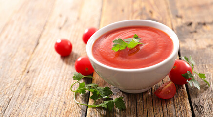 bowl of tomato soup on wood background