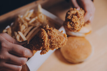 close up focus woman hand hold fried chicken for eat,girl with fast food concept