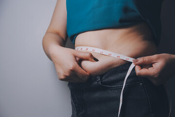fat woman, fat belly, chubby, obese woman hand holding excessive belly fat with measure tape, woman...