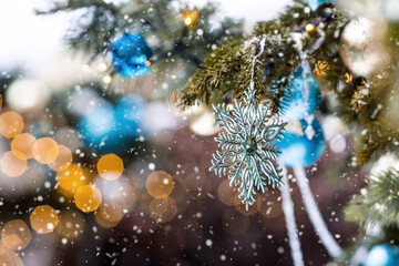 Beautiful festive snowflake decoration on the Christmas tree. Close-up. Beautiful Christmas background. The concept of decorations and decor for the new year. New Year's Card 2025