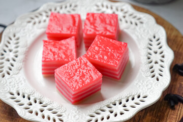 Kuih Lapis, a traditional Malay layered steamed cake and dessert, in white plates.
