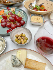 cheeses and glass of red wine on table