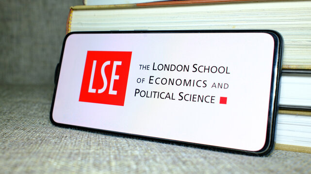 London School of Economics and Political Science (LSE) logo on phone screen with stack of books behind. London, UK, 08.25.2024