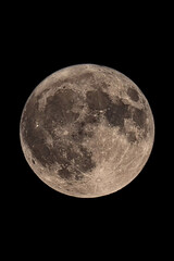 An original vertical photograph of the super blue moon with dark night background - full moon as seen through a telescope