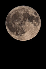 An original vertical photograph of the super blue moon with dark night background - full moon as seen through a telescope - space for caption