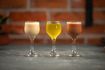 Glasses of assorted liquor on grey table