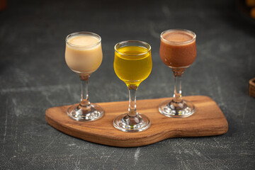 Glasses of assorted liquor on grey table