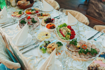 A table with a variety of food and drinks, including a salad, a sandwich, and a cake