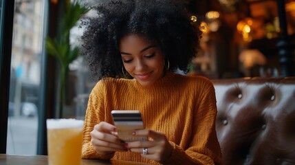 Shot of beautiful glad young female with Afro hairdo types number of credit card on smart phone makes purchase online or checks bank account recreats in outdoor cozy cafe with fresh co : Generative AI
