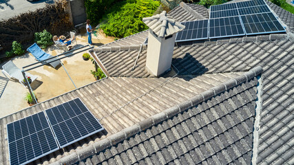 Aerial view of women relaxing and gardening in a backyard with solar panels