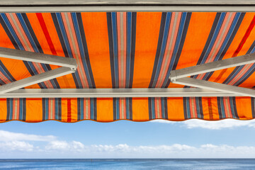 Store banne orange avec bras articulés
