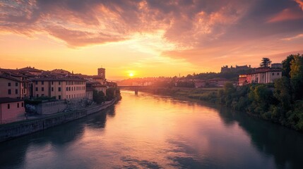 Obraz premium Sunset over a historic town by the river, with old buildings and calm waters creating a serene atmosphere.