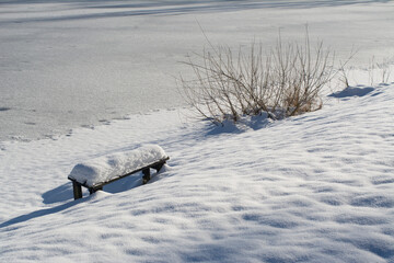 Biały puszysty śnieg pokrywający brzeg stawu. Zima. © ChemiQ