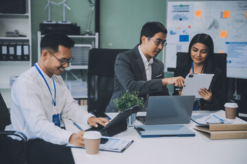 Group of colleagues engaging in a discussion during a business meeting in a conference room. Happy business people, men and women, collaborating and working towards their shared goals.