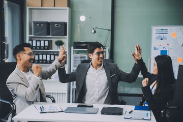 Group of colleagues engaging in a discussion during a business meeting in a conference room. Happy business people, men and women, collaborating and working towards their shared goals.