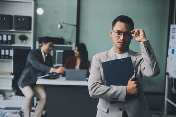 Group of colleagues engaging in a discussion during a business meeting in a conference room. Happy business people, men and women, collaborating and working towards their shared goals.