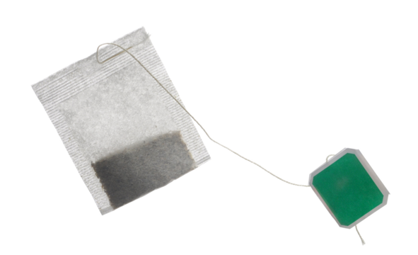 New tea bag with green tab isolated on white