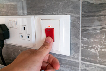 Switch is in the on position with a red light on the gray tile next to the UK sockets